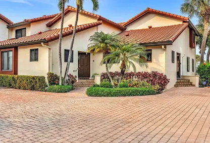 Villa del Alto (Highland Beach Isles) Townhomes in Highland Beach, FL featuring Mediterranean-style exterior, palm trees.